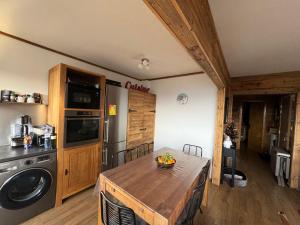 a kitchen with a table with a bowl of fruit on it at Le Petit Chalet du Belvédère in Font Romeu Odeillo Via +10 photos