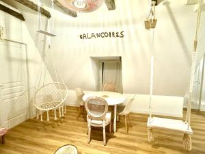 une pièce avec une table, des chaises et une balançoire dans l'établissement Caporizon-Les Balançoires de Sarlat, à Sarlat-la-Canéda