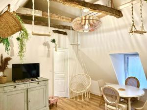 un salon avec une table, des chaises et une télévision dans l'établissement Caporizon-Les Balançoires de Sarlat, à Sarlat-la-Canéda 12 autres photos