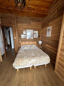a bedroom with a bed in a wooden cabin at Le Petit Chalet du Belvédère in Font Romeu Odeillo Via