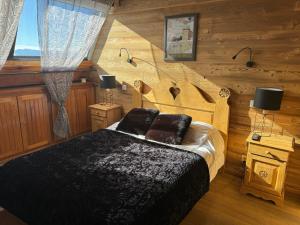 a bedroom with a bed in a log cabin at Le Petit Chalet du Belvédère in Font Romeu Odeillo Via