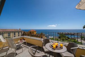 un balcon avec une table et des chaises et l'océan dans l'établissement Fort of Old Town Apartments by OurMadeira, à Funchal