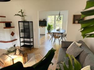 ein Wohnzimmer mit Couch und Tisch in der Unterkunft Stilvolles Haus mit Naturgarten & Weitblick - für Familien & Freunde in Oberschwarzach