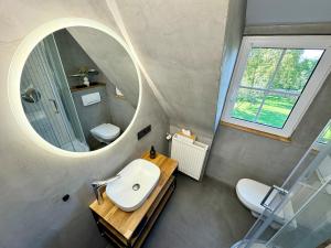 ein Badezimmer mit Waschbecken und Spiegel in der Unterkunft Stilvolles Haus mit Naturgarten & Weitblick - für Familien & Freunde in Oberschwarzach + 56 Fotos