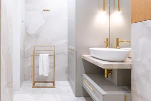 a white bathroom with a sink and a mirror at Apartament NEW YORK - nowy apartament z KLIMATYZACJĄ w centrum miasta - podziemny parking w cenie in Nowy Targ