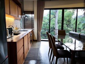 a kitchen with a table with chairs and a dining room at Villa 173 - Two bedroom private villa in Ban Pak Chong Noi
