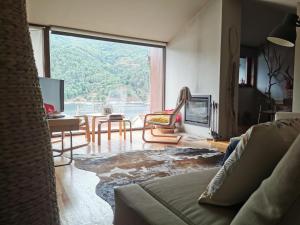 a living room with a couch and a large window at Casa do Bairro da Veiga in Pereiro