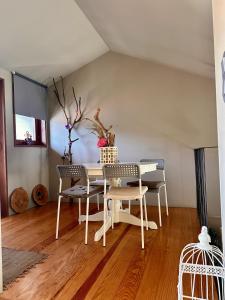 a dining room with a white table and chairs at Casa do Bairro da Veiga in Pereiro