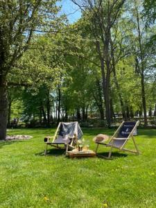 two camping chairs and a tent in a park at Hotel Jakubus in Wilków