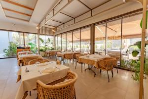a restaurant with tables and chairs and windows at Keptur Hotel in Dosemealti