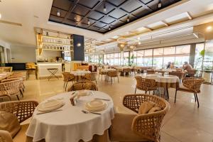 a restaurant with white tables and chairs and windows at Keptur Hotel in Dosemealti +34 photos