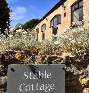 a sign in front of a building with a sign in front at Stable Cottage, Oxfordshire in Oxford