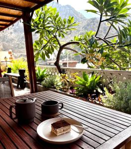a piece of cake on a wooden table with two cups at Tamahuche Hotel Rural in Vallehermoso