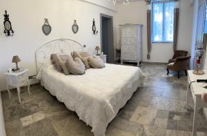 a bedroom with a large white bed with pillows at Les Cèdres de Nauton in Vergoignan
