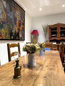 a dining room table with flowers in vases on it at Les Cèdres de Nauton in Vergoignan