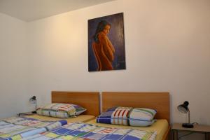 two beds in a room with a painting on the wall at Ferienwohnung Karolus in Sinsheim