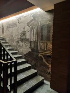 a mural on a wall next to a staircase at Tsalamuri Old Tbilisi in Tbilisi City