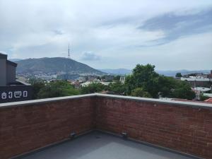 a brick wall with a view of a city at Tsalamuri Old Tbilisi in Tbilisi City +39 photos