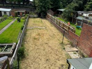 an empty backyard with a fence and a garden at 3 bedroom cosy home in Birmingham in Oldbury