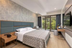 a bedroom with a large bed and a large window at Keptur Hotel in Dosemealti