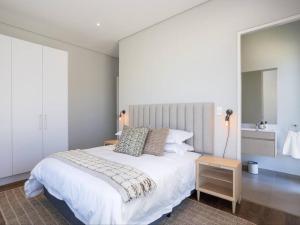 a bedroom with a large white bed and a table at Luxury Villa 712 Pearl Valley Golf Estate in Paarl +21 photos