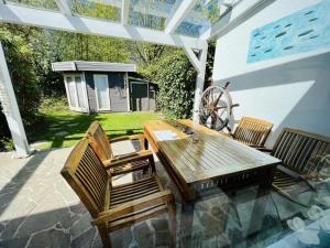 a wooden table and chairs on a patio at Ferienhaus Matrose in Warnemünde