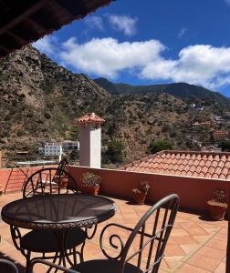 a patio with a table and chairs on a roof at Tamahuche Hotel Rural in Vallehermoso
