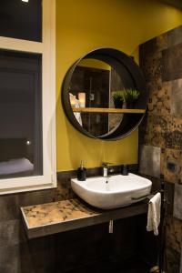 y baño con lavabo y espejo redondo. en Home In City, en Palermo 25 fotos más