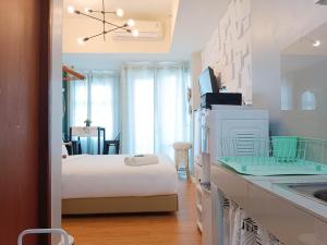 a room with a kitchen with a bed and a sink at Warm and Homey Studio at Vida View Makassar Apartment By Travelio in Pampang +13 photos