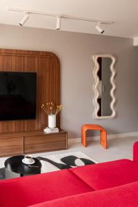 a living room with a red couch and a tv at Apartament KOPENHAGA - nowoczesny i stylowy apartament w centrum miasta z miejscem parkingowym in Nowy Targ