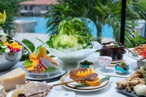 a table topped with plates of food and bowls of food at RISONARE Kohamajima in Kohama