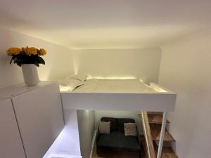 een kleine kamer met een bed en een vaas met bloemen bij Studio Metro Paris La-defense in Asnières-sur-Seine