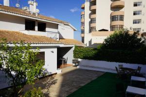 a view of the courtyard of a house with two buildings at Sky and Sand Hostel in Portimão