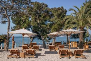 a group of chairs and umbrellas on a beach at ME Ibiza - The Leading Hotels of the World in Santa Eularia des Riu +153 photos