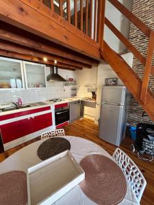 a kitchen with a table and a refrigerator and a counter at Appartement au cœur de Périgueux in Périgueux