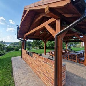 a pavilion with tables and benches on a brick wall at Uroczysko Lutówko in Sępólno Krajeńskie