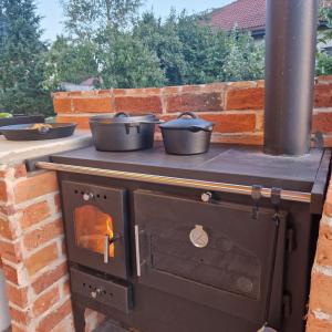 a stove with three pans on top of it at Uroczysko Lutówko in Sępólno Krajeńskie +240 photos