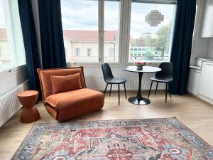 a living room with a chair and a table in front of a window at Spacious Railway Station Apartment in Oulu +9 photos