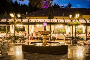 a fountain in the middle of a courtyard with tables and chairs at Luxury Apartment Rich 3 in Velingrad