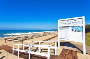 a sign on a beach with chairs and the ocean at Virgilio Grand Hotel in Sperlonga