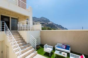 a stairway to a building with two chairs and a table at Michaela Beach House , By ThinkVilla in Plakias