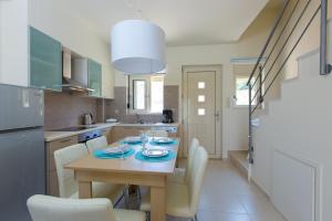 a kitchen with a table with chairs and a dining room at Michaela Beach House , By ThinkVilla in Plakias +7 photos