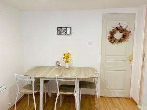 a dining room table with chairs and a white wall at Flat near paris in Épinay-sur-Seine +7 photos