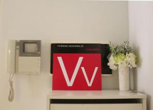 Un cartel rojo encima de un escritorio con flores. en Apartment Balcon, cosy one bed with AirCon and pool, en Puerto de Santiago