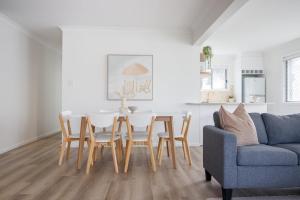 a living room with a table and chairs and a couch at Palms on Tugun in Gold Coast