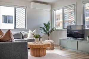 ゴールドコーストにあるPalms on Tugunのソファとテレビのあるリビングルーム