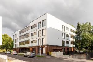 a white building on a street with cars parked in front at Parkside Lux - 2 bedrooms Apartment, New in Tallinn
