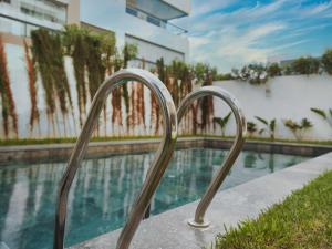 a metal stairway leading to a swimming pool at Sancy Luxury rez de jardin avec piscine privée in Casablanca +11 photos