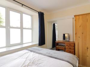 a bedroom with a bed and a dresser and windows at West Morton Suite in Thornhill