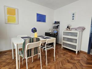 a dining room with a white table and chairs at Apartment Magdica in Malinska
